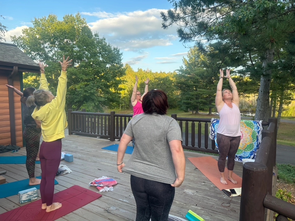 A group of people doing yoga on the deck.