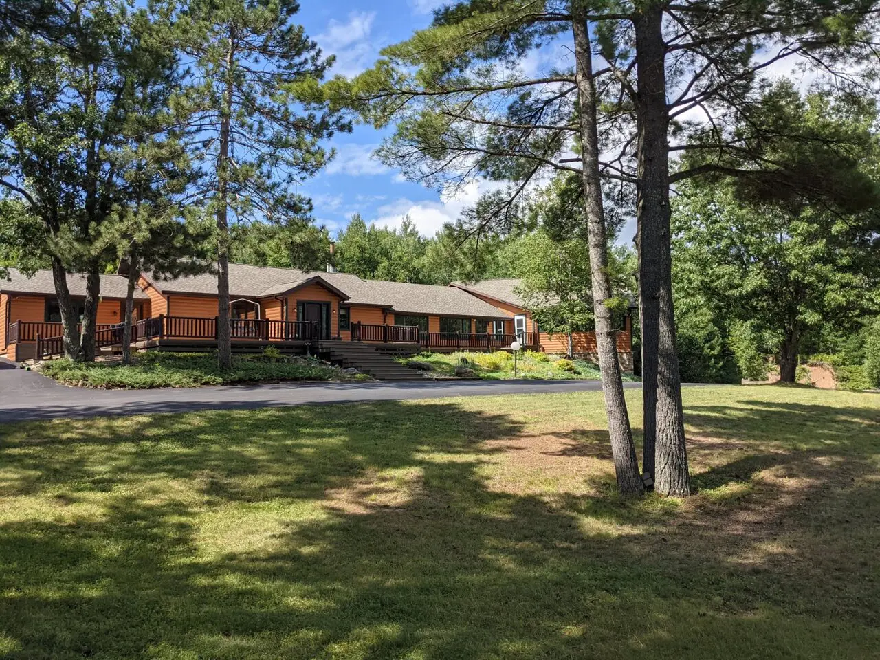 A large house in the woods with trees around it