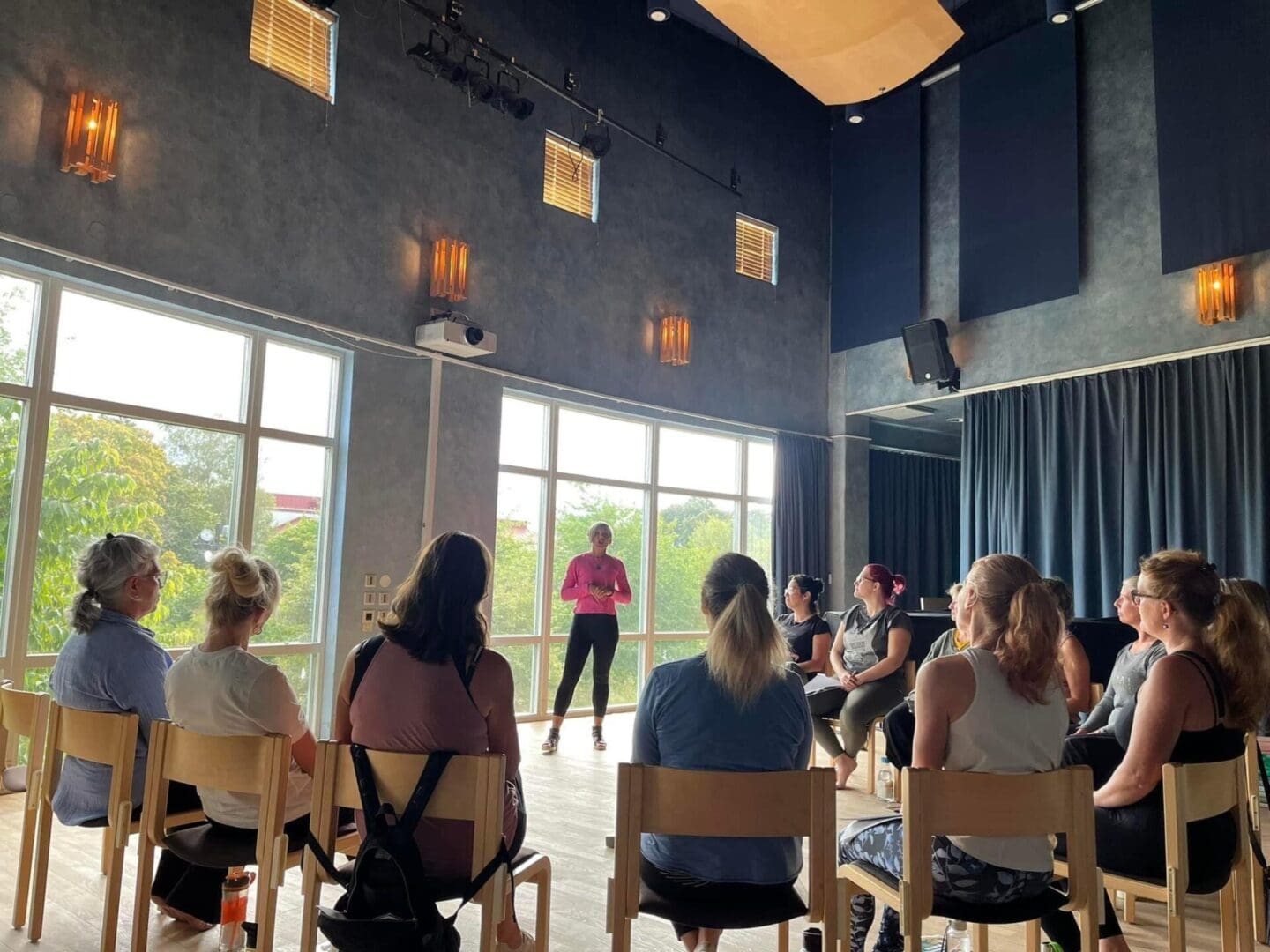 A group of people sitting in chairs watching an instructor.